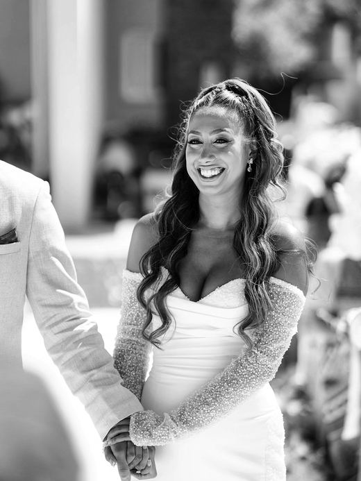 The bride smiling, holding hands at the ceremony